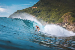 Surfer sur une vague en Indonésie